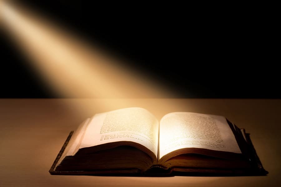 Bible open with light shining on pages, symbolizing meditation on Scripture