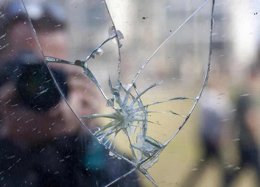 Man with camera reflected in broken window Man with camera reflected in shattered window exemplifying meaning of be sure your sin will find you out Numbers 32:23