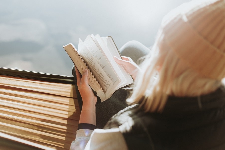 a woman reading the Bible outside.