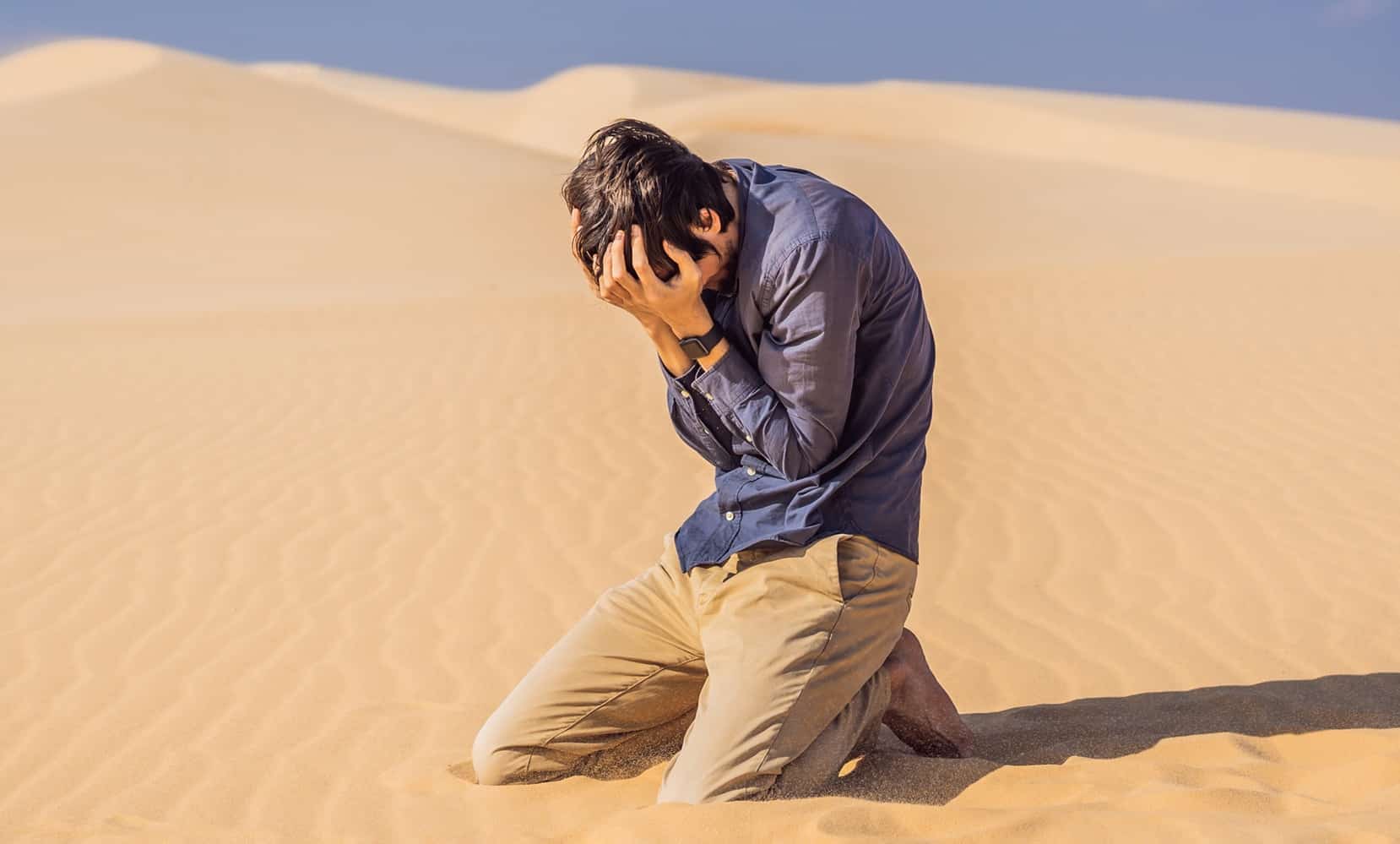 Man kneeling in a desert, symbolizing spiritual hunger and thirst for God